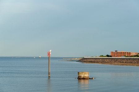 New Bedford, Massachusetts shoreline showing hurricane barrier, old factory and Butler's Flat Light Station with Acushnet River at low tideのeditorial素材