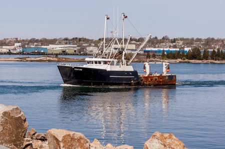 New Bedford, Massachusetts, USA - April 29, 2020: Scalloper Venture approaching hurricane barrier as...