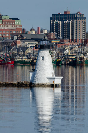 New Bedford, Massachusetts, USA - April 27, 2018: Palmer Island Light Station with fishing boats and buildings in backgroundのeditorial素材