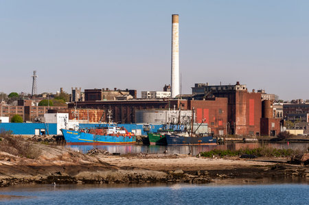 New Bedford, Massachusetts, USA - May 14, 2020: Fishing boats docked near processing plants and decommissioned New Bedford Gas and Edison Light Complexのeditorial素材