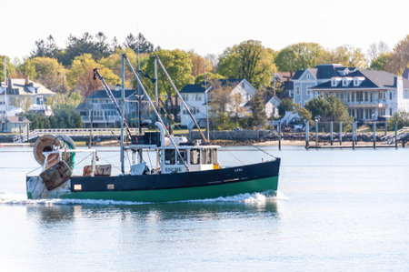 Fairhaven, Massachusetts, USA - May 14, 2020: Day boat Lual outbound with residential neighborhood...
