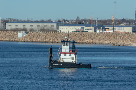 New Bedford, Massachusetts, USA - March 18, 2018: Small tug Grizzly on its way into Buzzards Bay after passing through hurricane barrier in New Bedford harborのeditorial素材