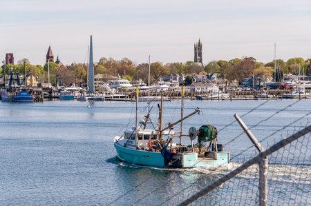 Fairhaven, Massachusetts, USA - May 14, 2020: Commercial fishing boat Underwing, hailing port Kingston, MA, transiting hurricane barrier with Fairhaven in backgroundのeditorial素材