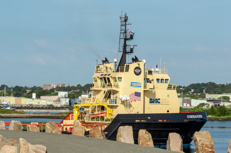 New Bedford, Massachusetts, USA - September 5, 2018: Offshore supply vessel Commander, hailing port Boston, Massachusetts, transiting hurricane barrier with New Bedford waterfront in backgroundのeditorial素材