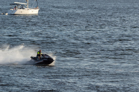 New Bedford, Massachusetts, USA - September 2, 2018: Rider cranking personal water craft across New Bedford outer harborのeditorial素材
