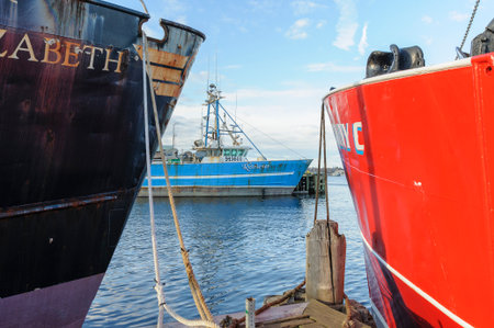 New Bedford, Massachusetts, USA - March 15, 2018: Fishing vessel Retriever framed by vessels Jane...