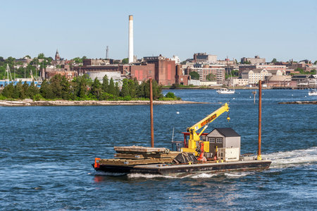 Fairhaven, Massachusetts, USA - June 8, 2020: Small tug and barge hauling equipment out of Fairhaven on breezy late spring morningのeditorial素材