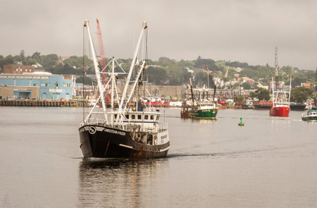 New Bedford, Massachusetts, USA - September 15, 2018: Eastern rig scalloper Christian and Alexa, hailing port Point Pleasant, New Jersey, leading other boats out of New Bedford on hazy morningのeditorial素材