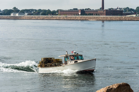New Bedford, Massachusetts, USA - September 15, 2018: Trap-laden lobster boat returning to New Bedford with factory in backgroundのeditorial素材