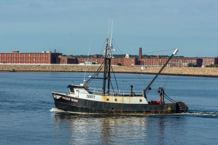 New Bedford, Massachusetts, USA - September 5, 2018: Commercial fishing vessel Ocean Wave, hailing port Cape May, New Jersey, on Acushnet River with New Bedford hurricane barrier in backgroundのeditorial素材