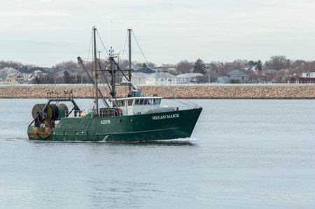 New Bedford, Massachusetts, USA - March 28, 2018: Fishing vessel Megan Marie, hailing port Montauk, New York, on Acushnet River with hurricane barrier in backgroundのeditorial素材