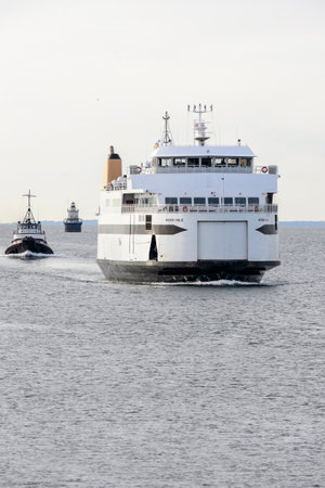 New Bedford, Massachusetts, USA - March 23, 2018: Ferry Woods Hole and tug Morgan with Butler's Flat Light Station background in New Bedford outer harborのeditorial素材