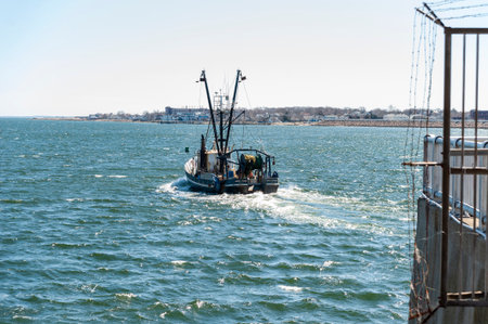 New Bedford, Massachusetts, USA - March 31, 2018: Trawler Mattie and Maren, hailing port Point Judith, RI, outbound from New Bedford in glistening afternoon chopのeditorial素材
