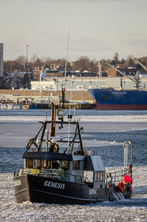 New Bedford, Massachusetts, USA - January 9, 2018: Lobster boat Genesis on icy Acushnet River with New Bedford waterfront in backgroundのeditorial素材