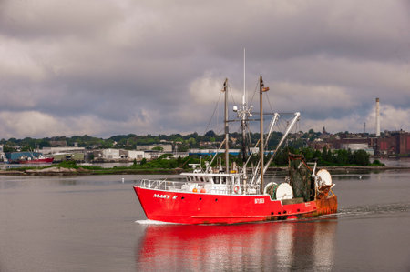 New Bedford, Massachusetts, USA - July 1, 2020: Commercial fishing boat Mary K glowing in sunlight that has found a hole in the cloudsのeditorial素材