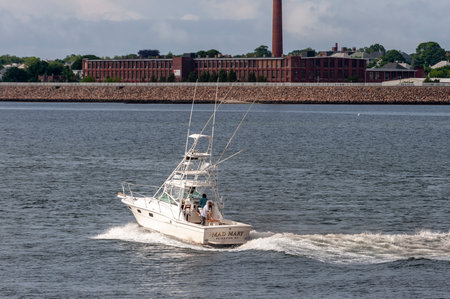 Fairhaven, Massachusetts, USA - July 1, 2020: Sun spotlights sport fishing boat Mad Mary through break in storm cloudsのeditorial素材