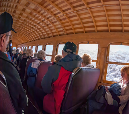 Mount Washington, New Hampshire, USA - October 2, 2009: Morning sun begins to brighten passenger car as Cog Railway train climbs above cloud layerのeditorial素材