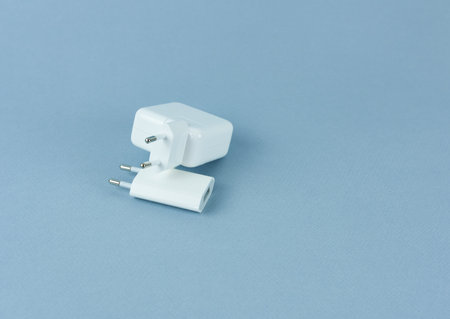 Phone and tablet charger close-up on blue background.