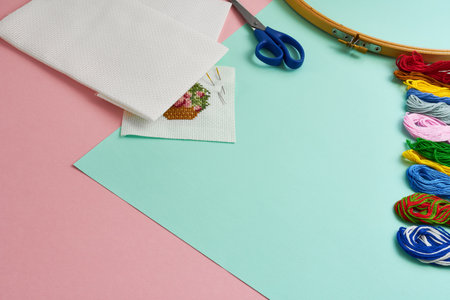 Embroidery set on a pink and turquoise background. The concept is a hobby.の写真素材