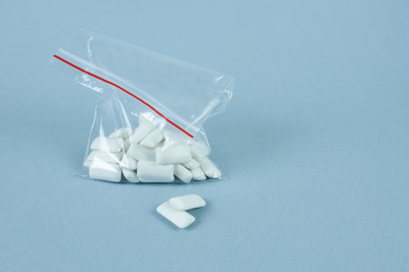 Close-up of chewing gum pads in a bag on a blue background. The concept is an import ban.の写真素材