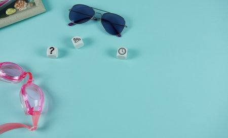 Sunglasses with cubes and a photo frame on a blue background. The concept is vacation planning.