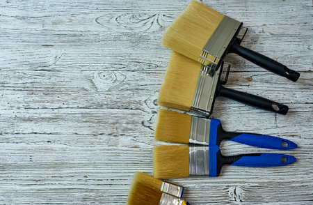 Paint brushes on a white wooden background. Top view with copy space.