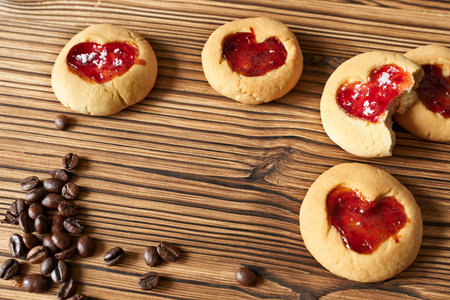 Sand cookies with hearts on a wooden background with coffee beans.の写真素材