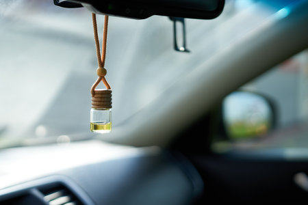 Close-up of an air freshener hanging from a car mirror against a blurry backgroundの写真素材