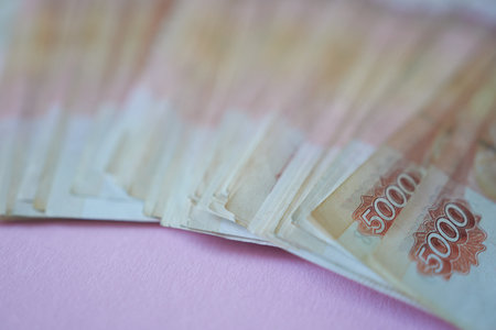 5000 rubles on a pink background, selective focus. A lot of bills on a pink background.