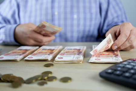 Businessman counting money in the office, close-up of handsの写真素材