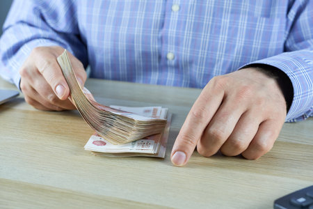 A businessman counting money, close-up of hands counting Russian rubles.