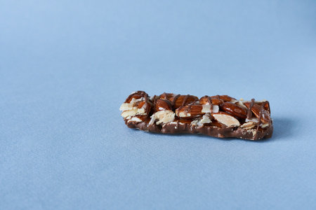 Nut bar with chocolate on a blue background. Close-up.の写真素材