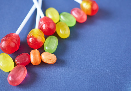 Lollipop caramel on a blue background. Multicolored caramel, selective focus.の写真素材