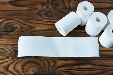 Rolls of cash register tape. Cashier's check form on wooden backgroundの写真素材