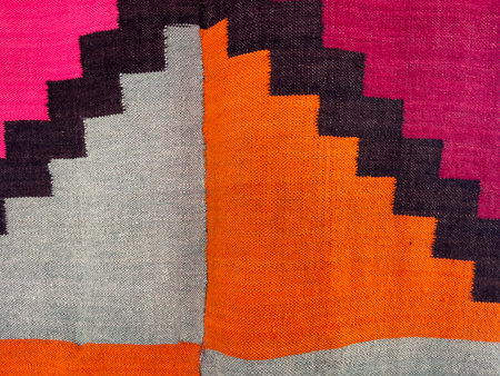 Fragment of colorful hand woven carpet. Abstract background and texture for design.
