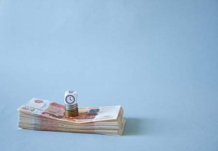 A wad of money on a blue background with space to copy text. The concept is accumulation of money.の写真素材