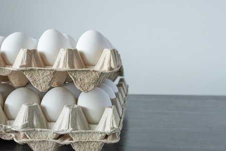 Eggs in carton box on wooden table with copy spaceの写真素材