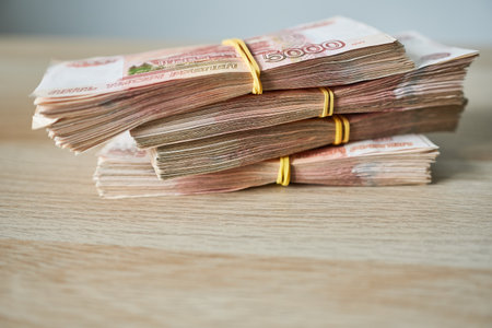 Bundle of Russian rubles banknotes on a wooden table.