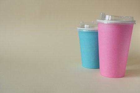 Colorful paper coffee cup for take away on beige background.の写真素材