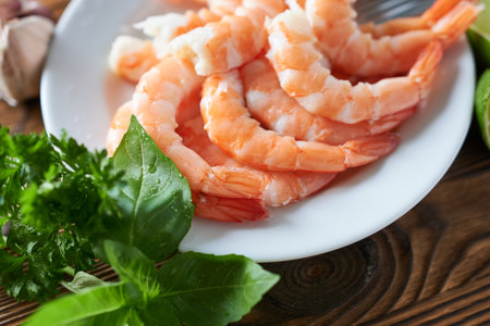 Shrimps with garlic and parsley on wooden table, closeupの写真素材