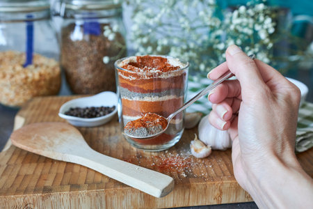 Close-up of a woman's hand with a spoonful of spices. The concept of cooking.の写真素材