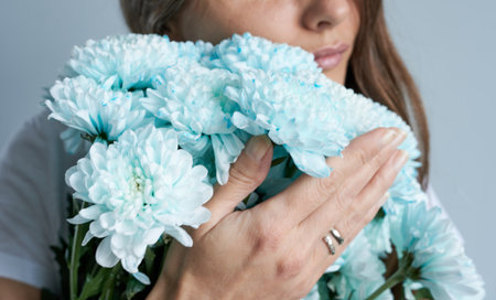 Close-up of a woman holding a bouquet of blue flowersの写真素材