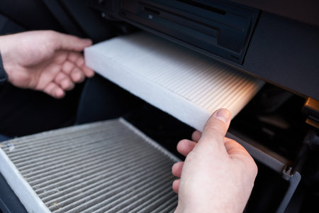 Close-up of a car air filter in the hands of a man