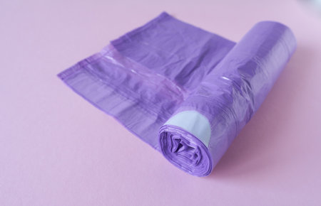 Roll of purple plastic garbage bags on pastel pink background. Copy space.の写真素材