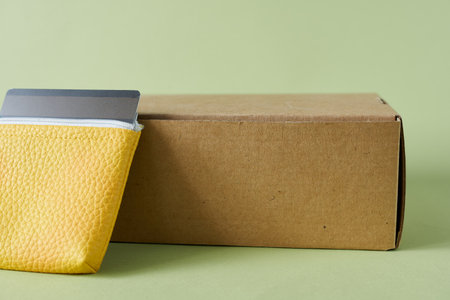 Cardboard box and wallet on a green background. Close up.