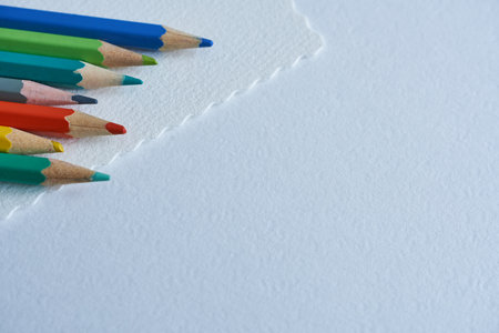 Colored pencils on a white sheet of paper with copy spaceの写真素材