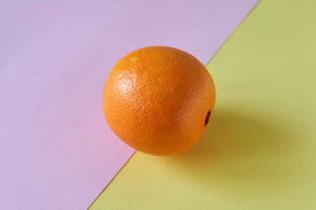 Orange fruit on pastel background. Minimal still life photography.の写真素材