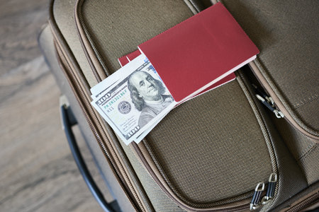 Suitcase with passport and dollars on wooden background. Travel conceptの写真素材