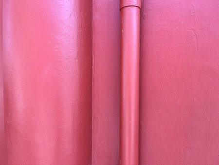 pink plastic pipe on the wall of the building, closeup of photo