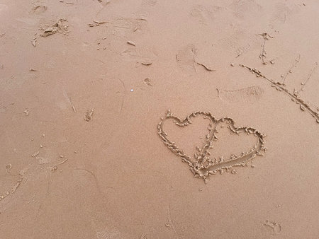 Two hearts drawn on the sand on the beach. Love concept.の写真素材